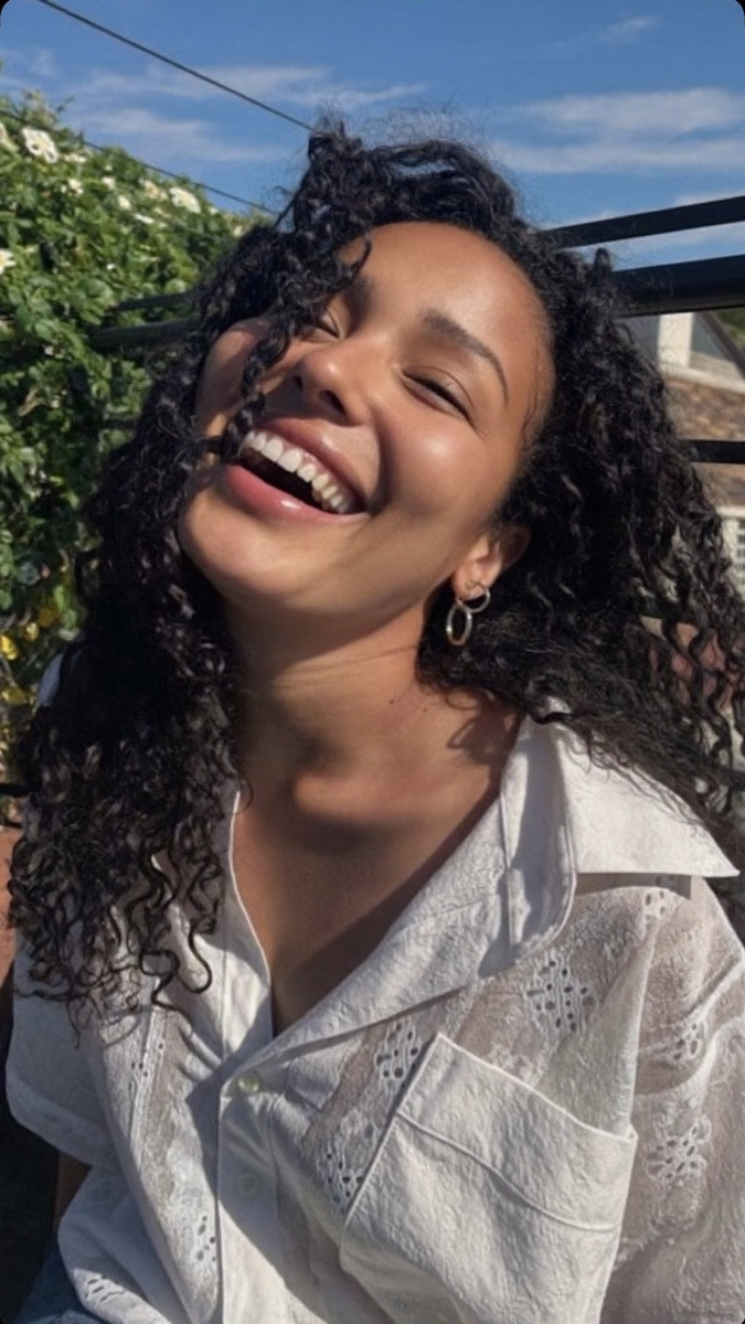 A woman laughing on a sunny terrace
